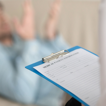 A psychologist listens attentively during a therapy session, creating a calm and supportive environment for the client.