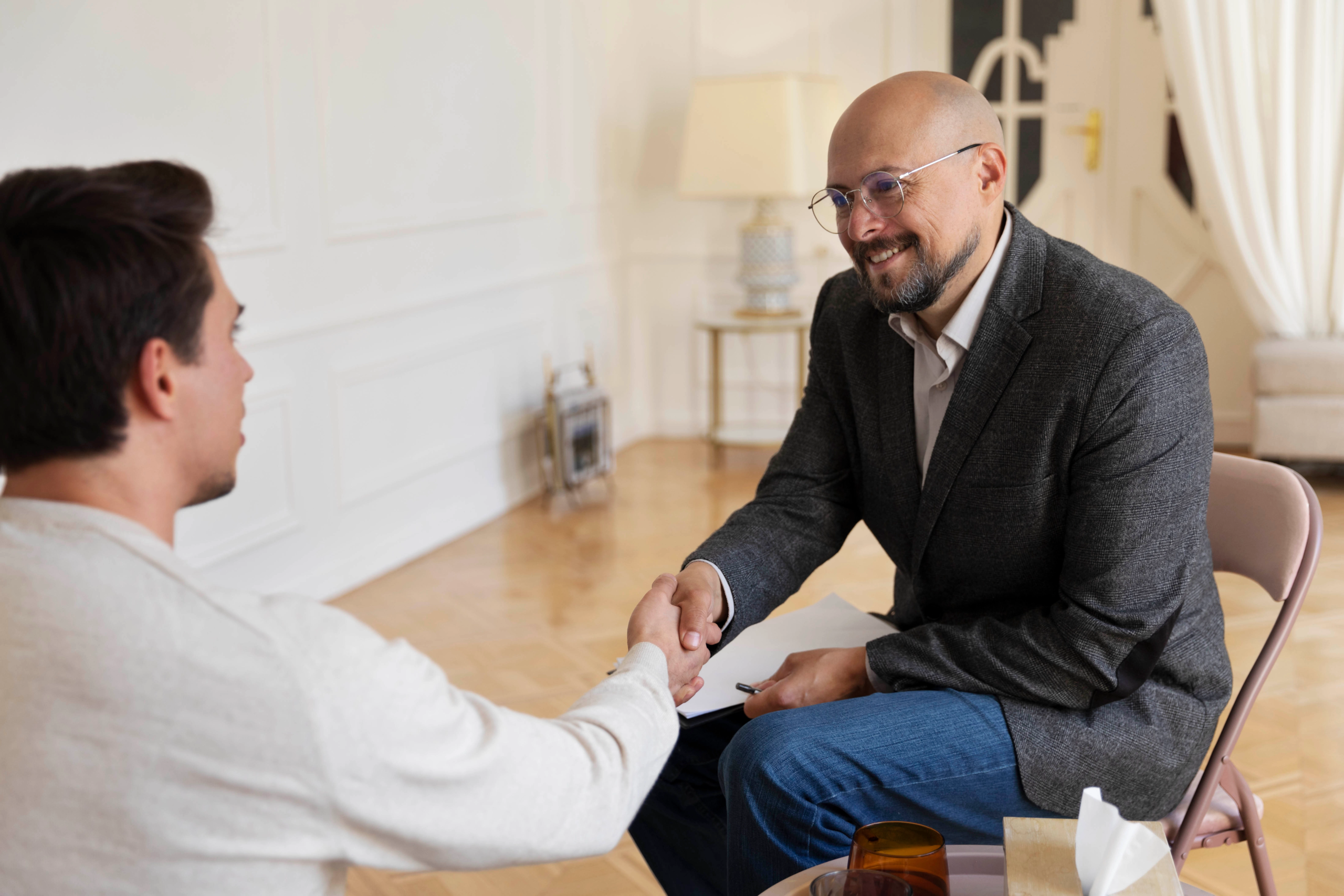 A therapist in Islamabad warmly greeting a client during a counseling session in a comfortable office.